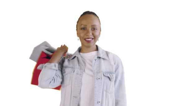Портрет афро-американської жінки з сумками для покупок п'є каву на білому фоні в студії. Жана куртка — стокове відео
