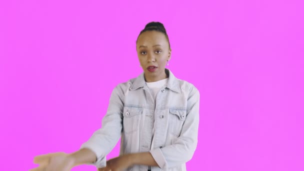 Retrato de niña afroamericana molesta perpleja mirando en cámara sobre fondo rosa. Expresión facial de palma chaqueta Jean — Vídeos de Stock