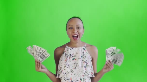 Zadowolony szczęśliwy podekscytowany Afryki amerykańskiej kobieta pokazując pieniądze i mówiąc O Mój Boże na zielonym tle Biała sukienka z kwiatami — Wideo stockowe