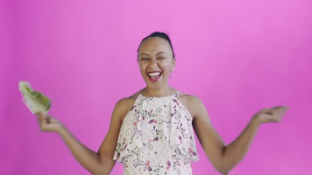 Задоволена щаслива афро-американська жінка, що показує гроші і каже "Так на рожевому тлі". Біла сукня з квітами. — стокове відео
