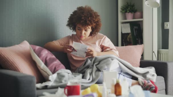 Enfermo afroamericano chica está leyendo instrucciones de medicación — Vídeo de stock