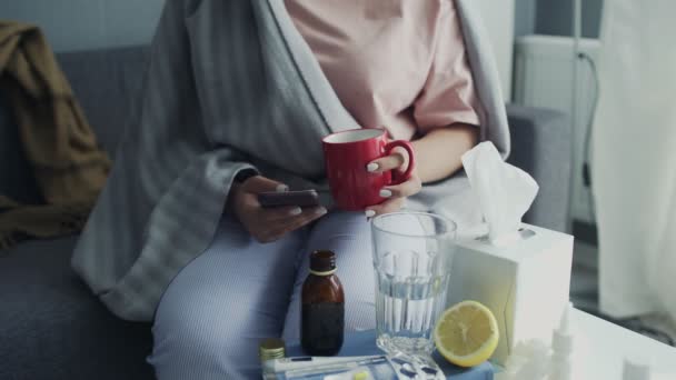Close up de doente Jovem afro-americana usando telefone e beber um chá quente em casa — Vídeo de Stock