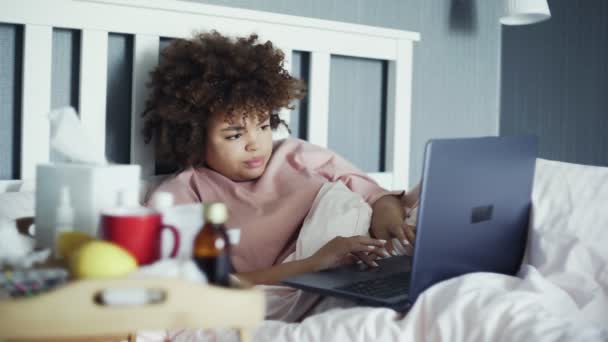 Malato freelancer afro-americano ragazza con influenza che lavora a letto con notebook — Video Stock
