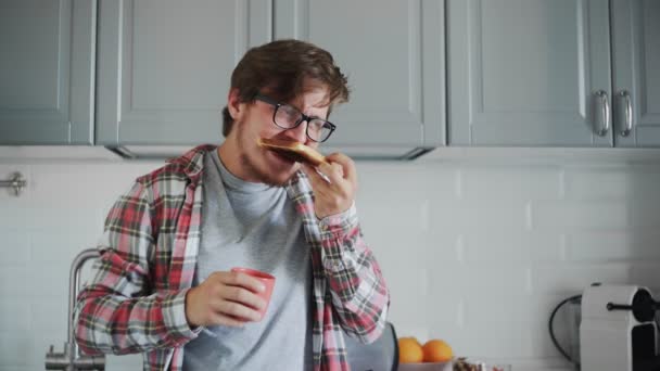 若い男は古いパンを食べ、シンクに嘔吐 — ストック動画