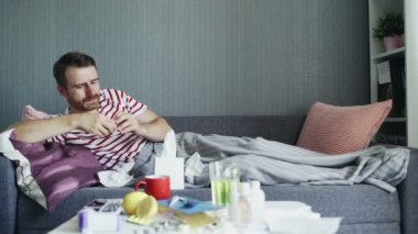 Yetişkin hasta bir adam kanepede yatar ve hastalık için reçeteli ilaç alır..