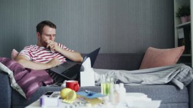 Hasta sakallı adam dizüstü bilgisayarla komedi şovu izliyor.