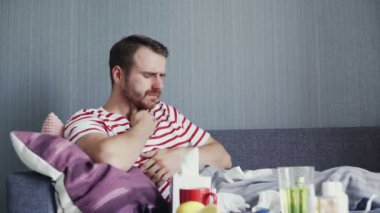 Genç hasta adam evde sıcak çay içiyor.