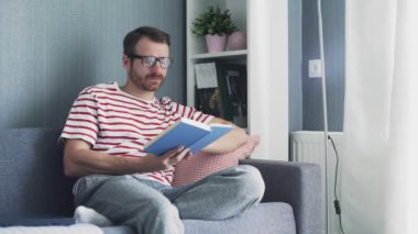 Kafkasyalı genç, gözlüklü, kitap okuyan yakışıklı bir adam.