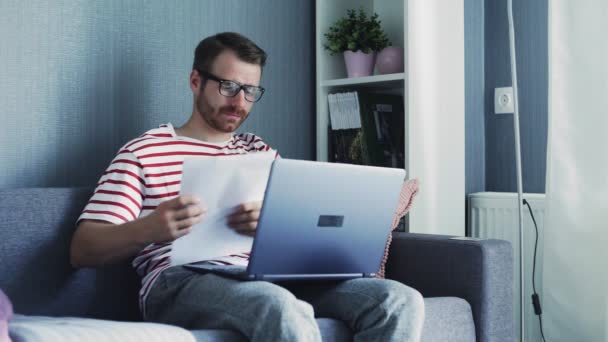 Hombre de negocios que trabaja con ordenador portátil y documentos en casa — Vídeos de Stock