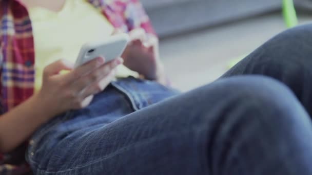 Красива молода жінка відпочиває на підлозі після прибирання і використання телефону — стокове відео
