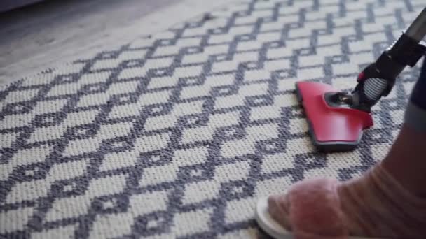 Mujer joven usando una aspiradora para limpiar la alfombra — Vídeos de Stock