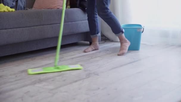 Vrouw is de vloer aan het wassen met dweilen en dansen thuis — Stockvideo