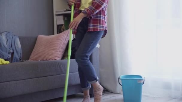 Slide shot van de vrouw is de vloer wassen met dweilen en dansen thuis — Stockvideo