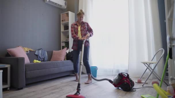 Mujer usando aspiradora escuchar música y bailar — Vídeo de stock