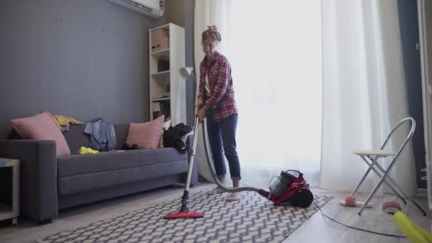 Žena použít vysavač k čištění koberce v obývacím pokoji během denního čištění. — Stock video