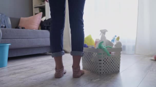Donna che cammina con cestino pieno di spugne e prodotti chimici per la casasa — Video Stock