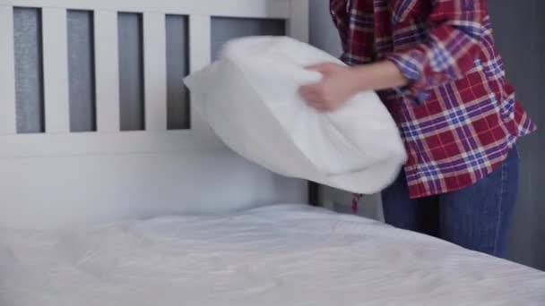 Γυναίκα που καθαρίζει το κρεβάτι της στο υπνοδωμάτιο, όμορφη γυναίκα που έχει συσταθεί και να κάνει το κρεβάτι, τακτοποίηση μαξιλάρια και μαξιλάρια τακτοποιημένα — Αρχείο Βίντεο