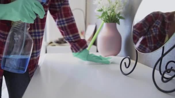 Mujer joven usando un trapo blanco para quitar el polvo de la mesa — Vídeo de stock