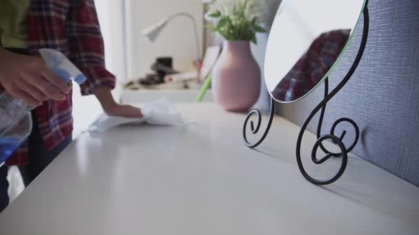 Jonge vrouw met een witte doek om stof van de tafel te verwijderen — Stockvideo