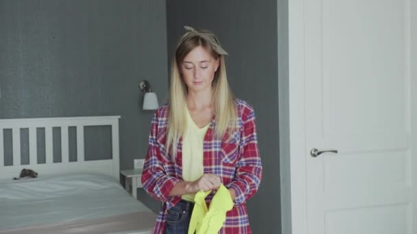 Junge Hausfrau zieht gelbe Handschuhe an — Stockvideo