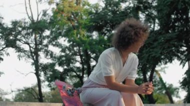 Parkta kaykaylı hippi genç bir kadın.