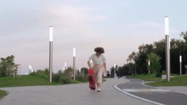 Genç profesyonel bayan kaykaycı parkta kaykay yapıyor.