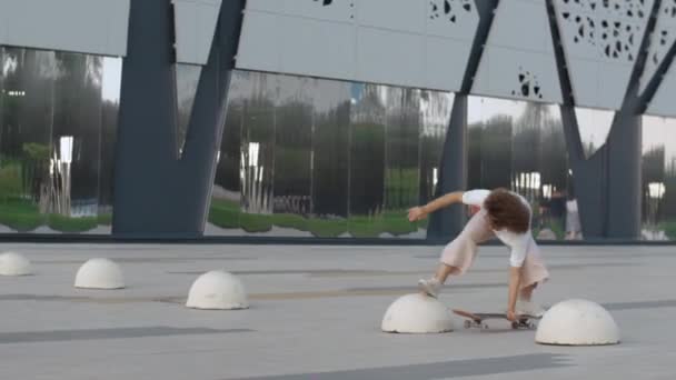 Jeune femme pro skateboarder faire des tours dans le parc — Video