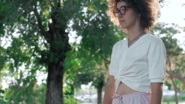 Hippi ve moda genç bayan parkta kaykayla poz veriyor.