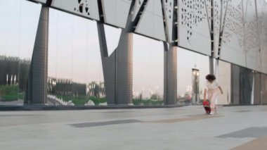 Genç bayan kaykaycı. Modern parkta kaykay ve zıplama numaraları.