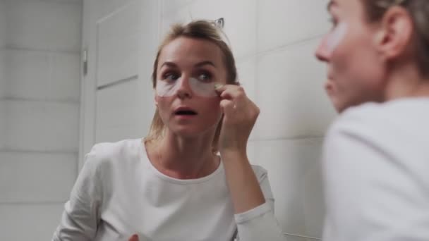Vrouw verwijdert vlekken op het gebied onder de ogen. — Stockvideo