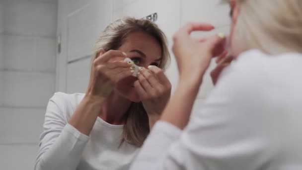 Mujer pone almohadillas de colágeno bajo sus ojos — Vídeo de stock