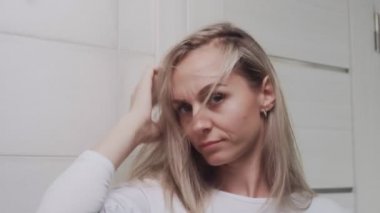 Hüsrana uğramış bir kız banyodaki kameraya bakar.