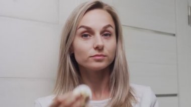 Kadın losyon sürüyor ve kameraya bakıyor.