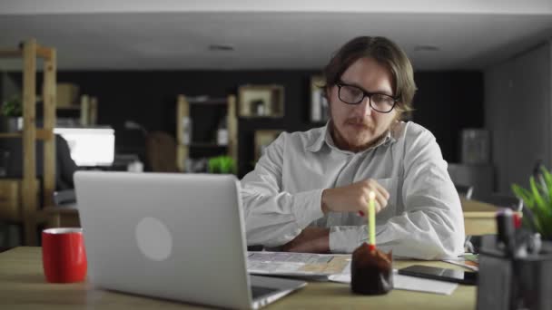 Грустный и уставший бизнесмен празднует одинокий день рождения в офисе — стоковое видео