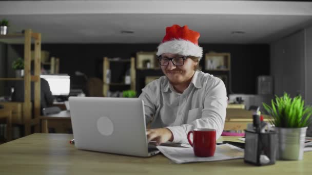 Gerente de bom humor trabalhando no computador portátil no escritório no Natal — Vídeo de Stock