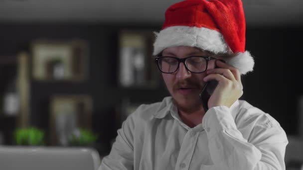 Бизнесмен выступает на смартфоне в офисе на Рождество — стоковое видео