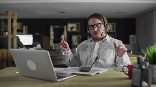 Manager in headphones is working at desk in office — Stock Video