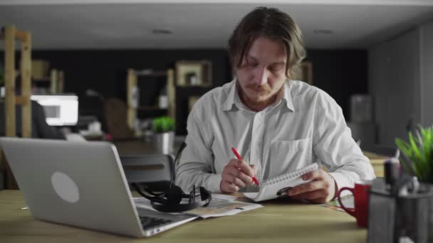 Jonge manager werkt in kantoor schrijven zitten aan de balie en ga weg — Stockvideo
