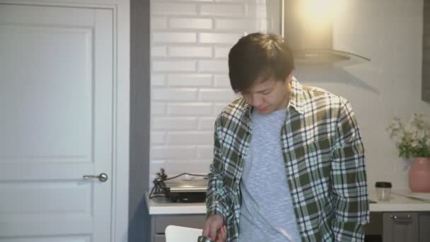 어린 아시아 남자 가집 부엌에서 터어 키 코 오피 를 하품하고 마시고 있다 — 비디오