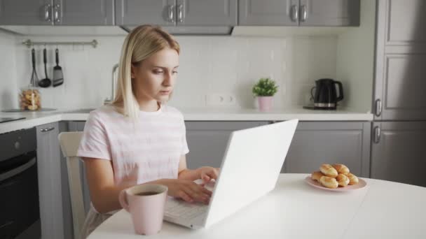 Üzletasszony gépel egy laptopon, miközben ül az asztalnál — Stock videók