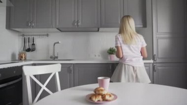 Genç Heyecanlı Kadın Akıllı Telefon Tutuyor ve Mutfakta Dans Ediyor.