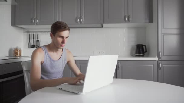 自宅でラップトップコンピュータで作業するときに勝者のジェスチャーを作る成功した男. — ストック動画