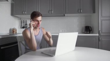 Freelancer telefonda konuşuyor ve mutfakta defter üzerinde çalışıyor..