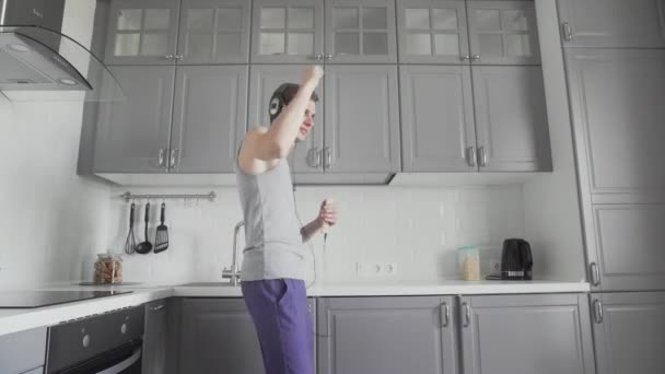 Jóképű vicces férfi táncol otthon a konyhában és jól érzi magát. — Stock videók
