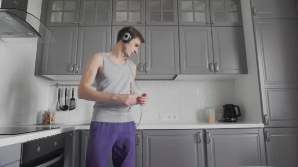 Egy fiatal férfi portréja, ahogy táncol a konyhában. — Stock videók
