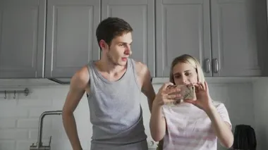 Sevimli bir kız gibi gülümseyen, poz veren ve sabah mutfakta selfie çeken tatlı bir adam.