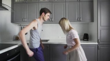 Pijama giyen güzel bir çift sabah dans ediyor, yeni güne hazırlanıyor, birlikte vakit geçiriyor, eğleniyor.