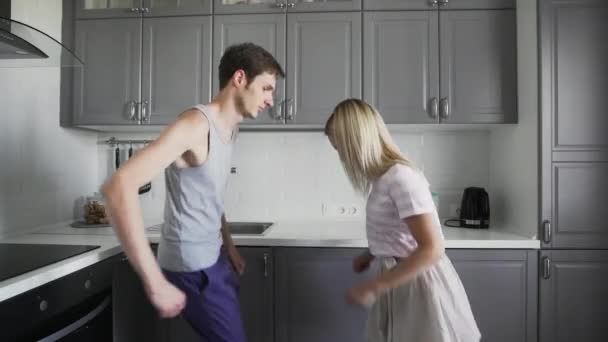 Bonita pareja con pijamas bailando graciosamente por la mañana, preparándose para un nuevo día, pasando tiempo juntos, divirtiéndose — Vídeo de stock