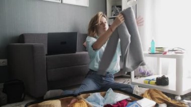 Güzel bir kadın bavulunu hazırlıyor. Yolculuk için hazırlanıyor. Seyahat planları yapıyor.