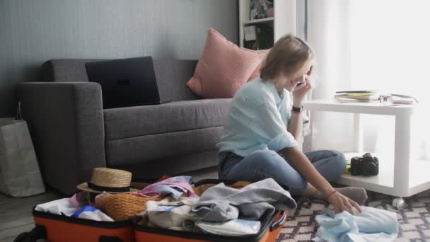 Menina bonito se preparando para viagem de carro, preparando bagagem e falando no smartphone — Vídeo de Stock